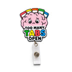 A novelty embroidered badge reel featuring a pink cartoon brain with colorful tabs and the text 'TOO MANY TABS OPEN' in multicolored letters, attached to a clear plastic swivel badge reel clip